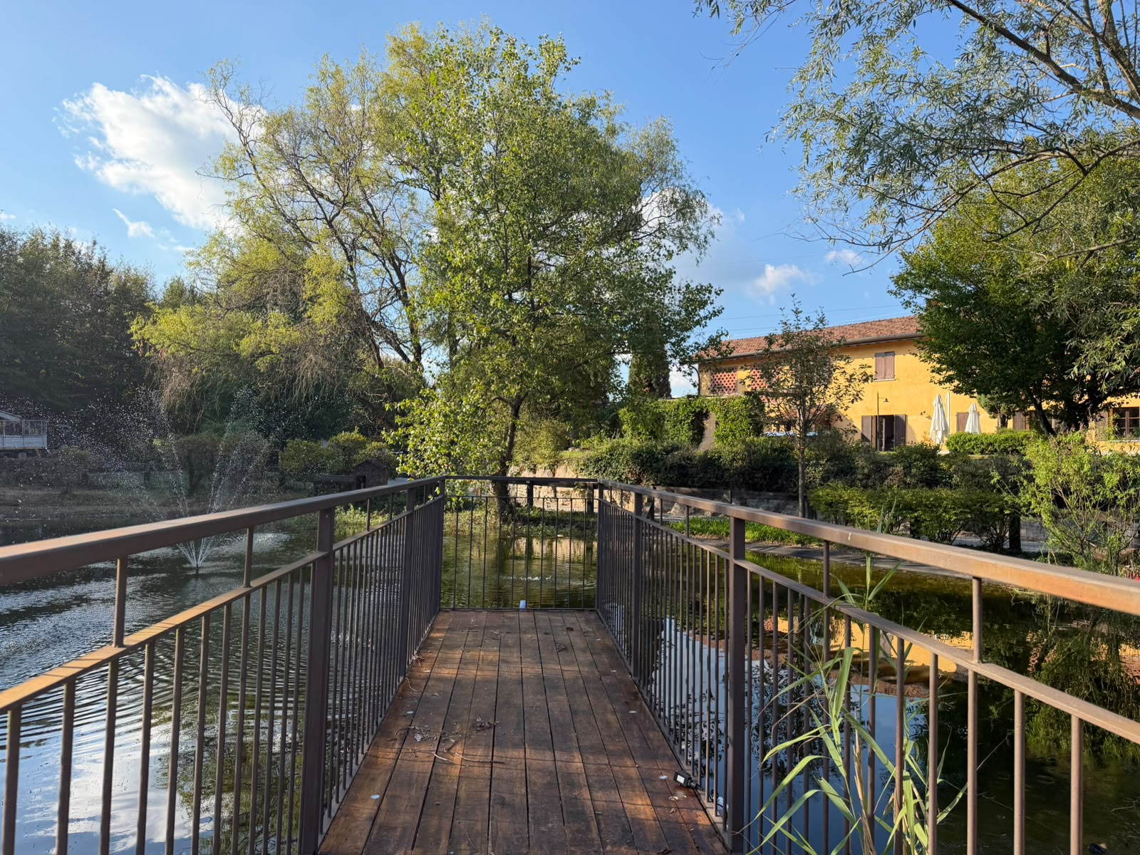Passerella sul laghetto con vista sulla cascina