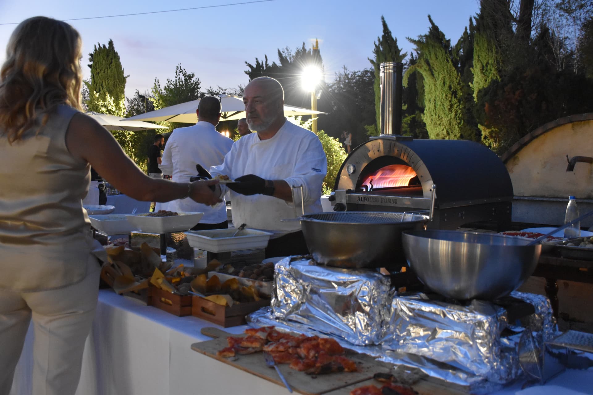 Forno a legna e buffet durante una serata in giardino